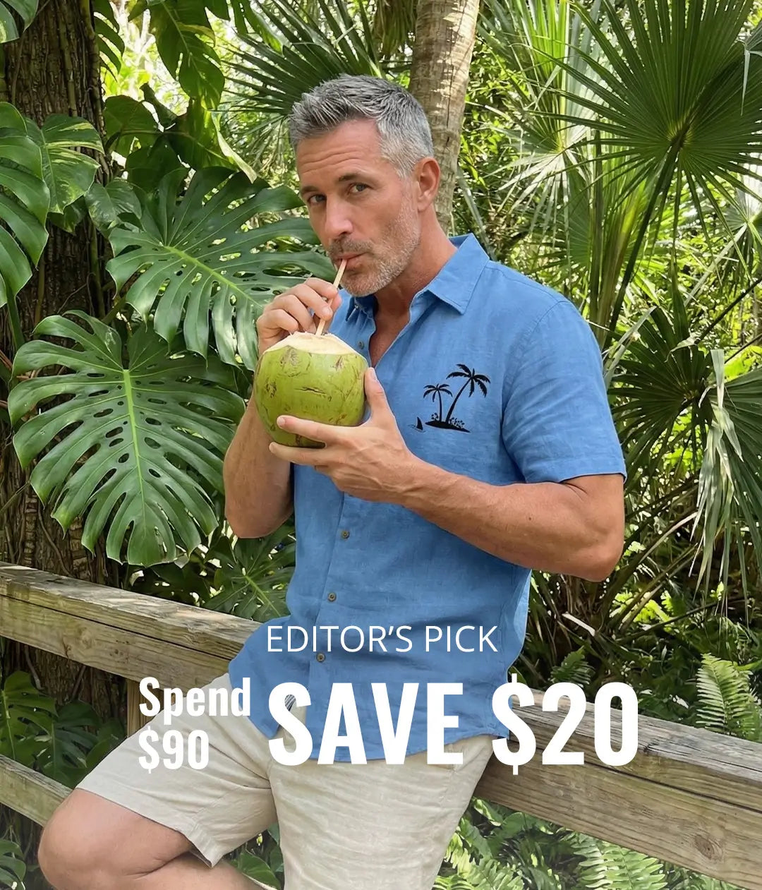 Man drinking from a coconut with tropical plants in the background